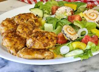 Πιάτο με σερβιρισμένο κοτόπουλο λεμονάτο και φρέσκια πράσινη σαλάτα.