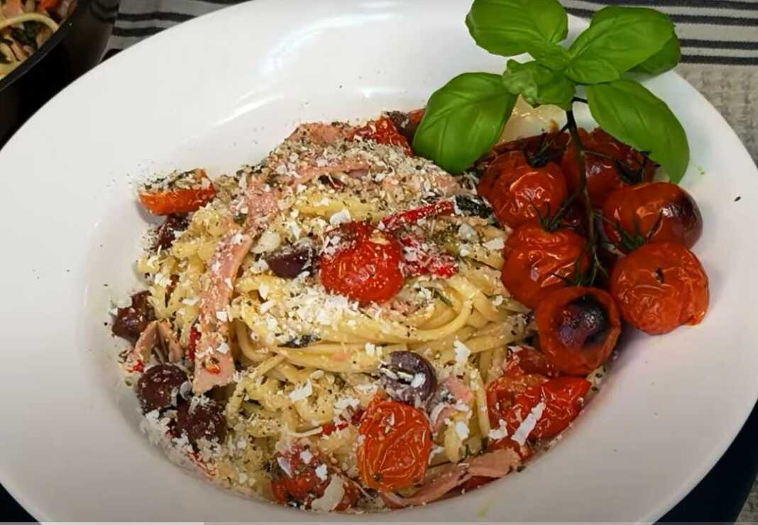 Λαχταριστή μακαρονάδα με ντοματίνια, ζαμπόν και τυρί, σερβιρισμένη σε πιάτο.