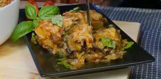 Κοντινό πλάνο σε μια μερίδα Μελιτζάνες με Λουκάνικο στο Φούρνο, που αναδεικνύει τις στρώσεις και τη χρυσαφένια κρούστα τυριού.