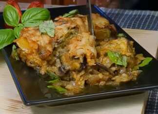 Κοντινό πλάνο σε μια μερίδα Μελιτζάνες με Λουκάνικο στο Φούρνο, που αναδεικνύει τις στρώσεις και τη χρυσαφένια κρούστα τυριού.