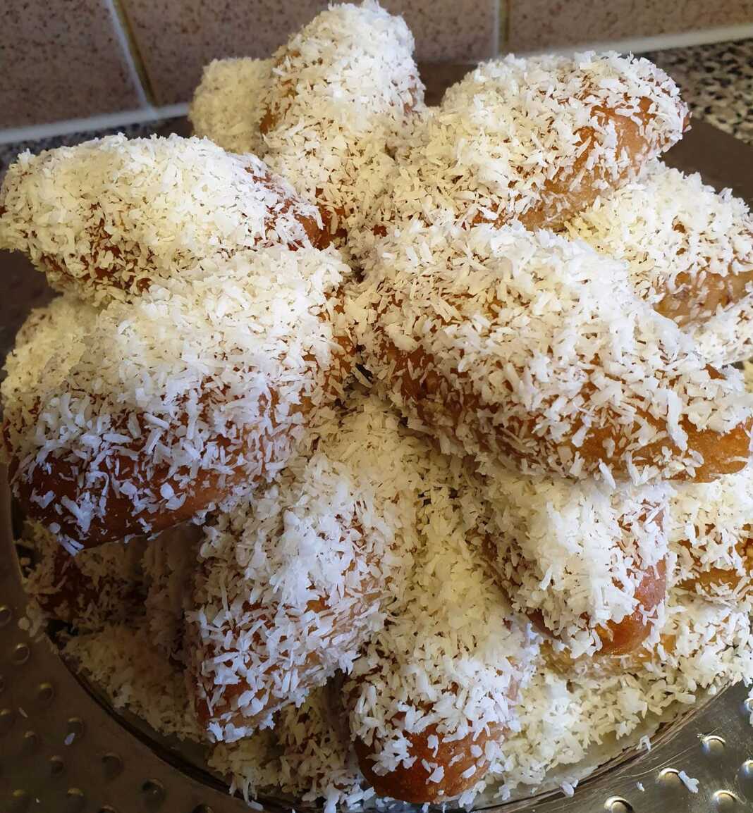 Πιάτο γεμάτο με χρυσαφένια Μεθυσμένα Κουλουράκια, πασπαλισμένα με ινδοκάρυδο