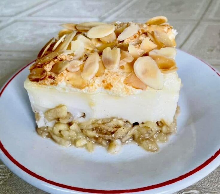 Κομμάτι Μηλόκρεμας με μήλα, που αναδεικνύει τις στρώσεις των μήλων, της κρέμας και της μαρέγκας.