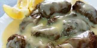 Ζεστά ντολμαδάκια με κιμά, περιχυμένα με χρυσαφένια σάλτσα αυγολέμονο, σε πιατέλα.