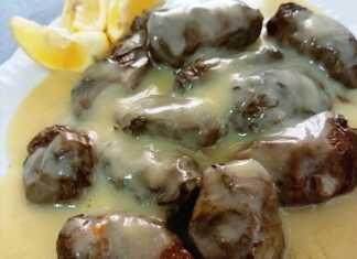 Ζεστά ντολμαδάκια με κιμά, περιχυμένα με χρυσαφένια σάλτσα αυγολέμονο, σε πιατέλα.