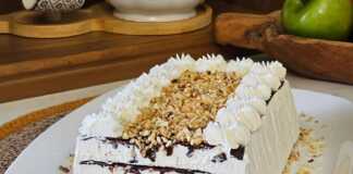 Ένα ολόκληρο Παγωτό Σοκολάτας με Στρώσεις, σε πιατέλα, διακοσμημένο με κρέμα, σιρόπι σοκολάτας και φουντούκια