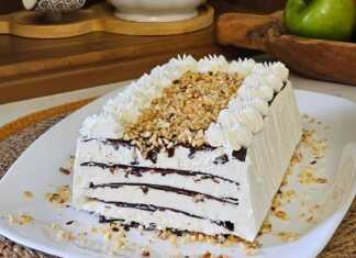 Ένα ολόκληρο Παγωτό Σοκολάτας με Στρώσεις, σε πιατέλα, διακοσμημένο με κρέμα, σιρόπι σοκολάτας και φουντούκια