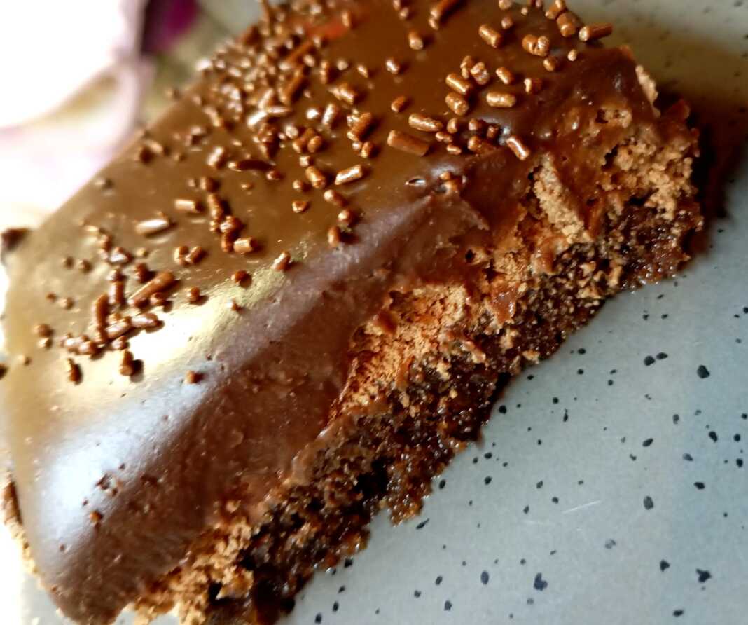 pasta sokolatina Λαχταριστή πάστα σοκολατίνα με στρώσεις παντεσπάνι, μους σοκολάτας και γκανάζ, διακοσμημένη με λιωμένη λευκή σοκολάτα.