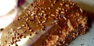 Λαχταριστή πάστα σοκολατίνα με στρώσεις παντεσπάνι, μους σοκολάτας και γκανάζ, διακοσμημένη με λιωμένη λευκή σοκολάτα.