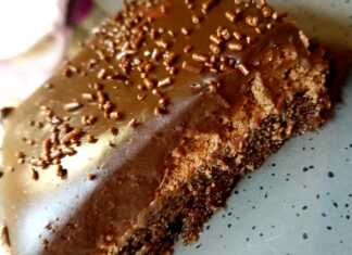 Λαχταριστή πάστα σοκολατίνα με στρώσεις παντεσπάνι, μους σοκολάτας και γκανάζ, διακοσμημένη με λιωμένη λευκή σοκολάτα.