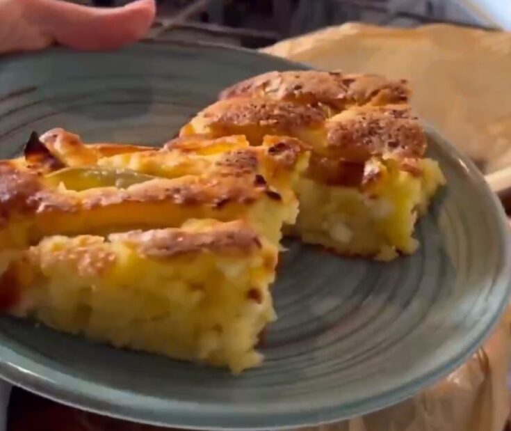 Κομμάτι από την πίτα με τυρί και μήλο, με ορατά τα κομμάτια μήλου και το ανθότυρο.