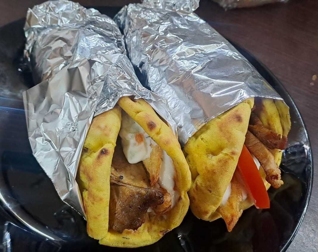 pites me xoirino giro Ένα πιάτο με λαχταριστές Πίτες με χοιρινό 'γύρο', πατάτες, ντομάτα και τζατζίκι."