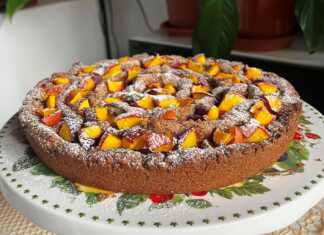 Μία ολόκληρη Σπιτική Γλυκιά Πίτα με Ροδάκινα, πασπαλισμένη με άχνη ζάχαρη, έτοιμη να κοπεί.