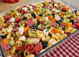 Σαλάτα τορτελίνια Πιάτο με πολύχρωμη σαλάτα τορτελίνια, γεμάτη λαχανικά, τυριά και σαλάμι, έτοιμη για σερβίρισμα σε καλοκαιρινό φόντο.