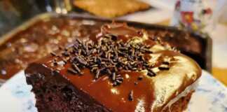 Κοντινή λήψη σε κομμάτι σοκολατόπιτας με πλούσιο γλάσο και ξύσμα πορτοκαλιού