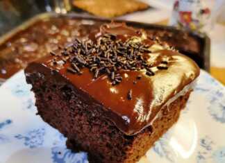 Κοντινή λήψη σε κομμάτι σοκολατόπιτας με πλούσιο γλάσο και ξύσμα πορτοκαλιού