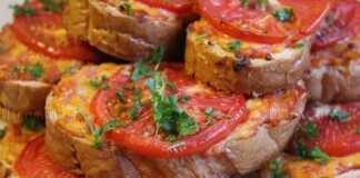 Κοντινό πλάνο σε ένα ζεστό τοστ Τεμπέλικη Πίτσα, με λιωμένο τυρί και μία φέτα ντομάτας