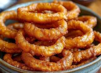 Ένα Πιάτο γεμάτο χρυσαφένια, τραγανά τηγανητά δαχτυλίδια κρεμμυδιού, έτοιμα για απόλαυση."