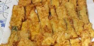 Ένα πιάτο γεμάτο με χρυσαφένια Τηγανητά Κολοκυθάκια, έτοιμα για σερβίρισμα