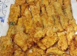 Ένα πιάτο γεμάτο με χρυσαφένια Τηγανητά Κολοκυθάκια, έτοιμα για σερβίρισμα