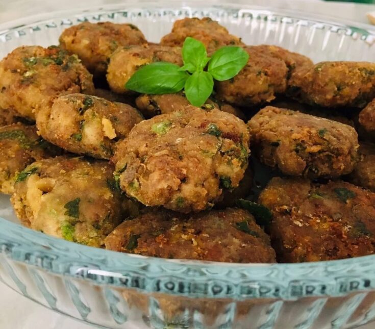 Χρυσαφένια τηγανητά κεφτεδάκια, σερβιρισμένα σε πιατέλα με απορροφητικό χαρτί, έτοιμα για απόλαυση.