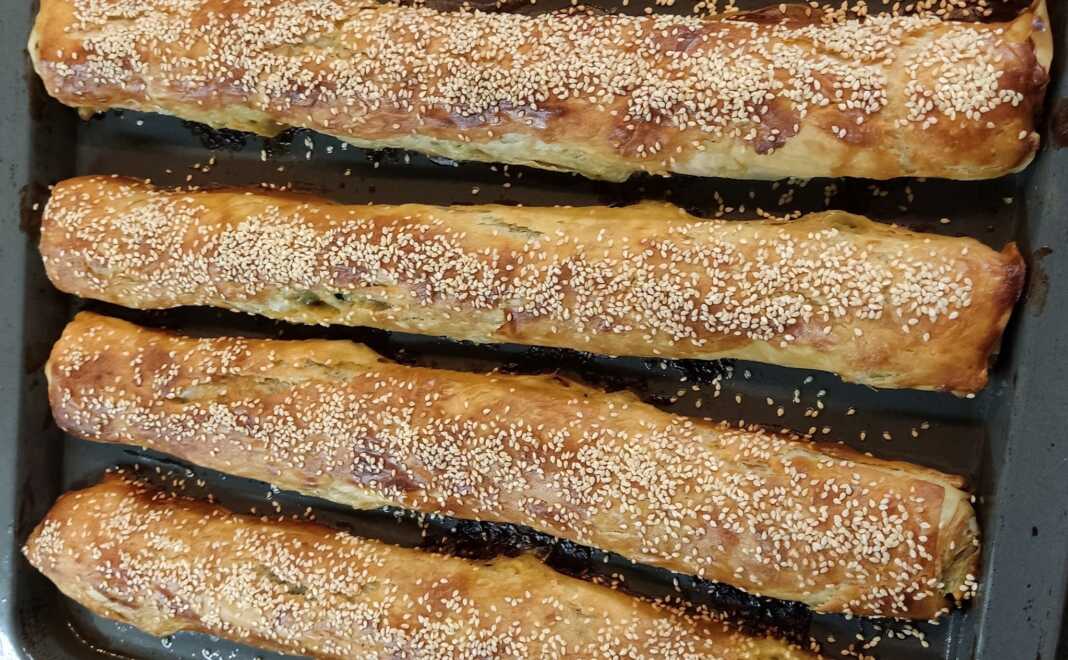 Τραγανή σπανακόπιτα με φύλλο κρούστας και σουσάμι, φρεσκοψημένη σε ταψί.