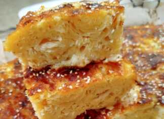 Τυρόπιτα με φύλλα κρούστας Πλούσια και αφράτη τυρόπιτα με φύλλα κρούστας, χρυσαφένια, κομμένη σε κομμάτια, πασπαλισμένη με σουσάμι, έτοιμη για σερβίρισμα.