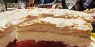 Κομμάτι από Αέρινη Τούρτα με Φράουλες και Μαρέγκα, που αναδεικνύει τις στρώσεις της μπισκοτένιας βάσης, του ζελέ, της κρέμας και της μαρέγκας