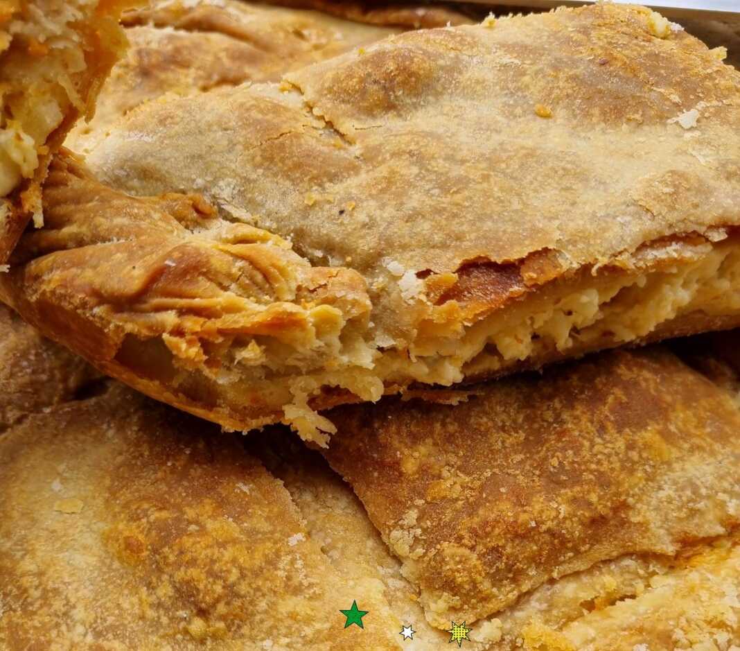 Μία Τραχανόπιτα , κομμένη σε κομμάτια, με χρυσαφένια κρούστα και ζουμερή γέμιση."