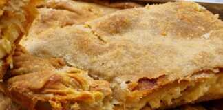 Μία Τραχανόπιτα , κομμένη σε κομμάτια, με χρυσαφένια κρούστα και ζουμερή γέμιση."
