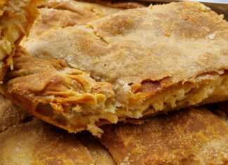 Μία Τραχανόπιτα , κομμένη σε κομμάτια, με χρυσαφένια κρούστα και ζουμερή γέμιση."