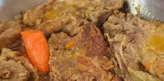 Χοιρινές μπριζόλες και χοντροκομμένα λαχανικά να σιγοβράζουν σε κατσαρόλα, μέσα στην αρωματική σάλτσα.