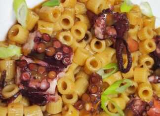 Ολοκληρωμένο Χταπόδι με Μακαρονάκι Κοφτό σε πιάτο, με πλούσια κόκκινη σάλτσα και ψιλοκομμένο μαϊντανό.