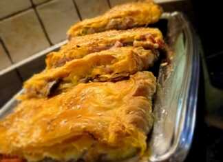 Κοντινό πλάνο σε κομμάτια από Ζαμπονοτυρόπιτα Σφολιάτας, που αναδεικνύει την πλούσια γέμιση με τυριά, ζαμπόν και λαχανικά