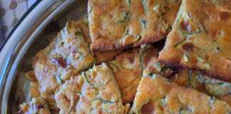 Κομμένο κομμάτι από την κολοκυθόπιτα που αναδεικνύει τα κολοκυθάκια και τη φέτα μέσα στη ζύμη.