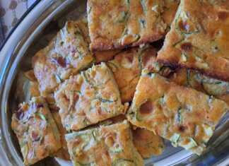 Κομμένο κομμάτι από την κολοκυθόπιτα που αναδεικνύει τα κολοκυθάκια και τη φέτα μέσα στη ζύμη.