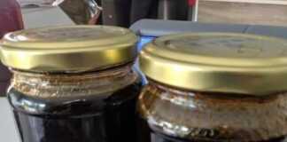 Δύο βάζα με σκούρο, παχύρρευστο βράσμα σύκων (πετιμέζι), με φρέσκα σύκα στο φόντο