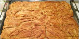 Μια ολόκληρη λουκανικόπιτα με τραγανό χειροποίητο φύλλο, με χρυσαφένιο χρώμα και σουσάμι στην επιφάνεια