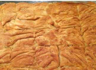 Μια ολόκληρη λουκανικόπιτα με τραγανό χειροποίητο φύλλο, με χρυσαφένιο χρώμα και σουσάμι στην επιφάνεια