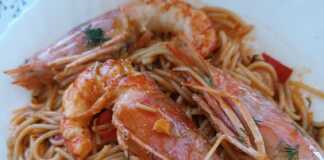 Ένα πιάτο με γαριδομακαρονάδα με ούζο, με πλούσια κόκκινη σάλτσα και μεγάλες γαρίδες