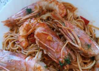 Ένα πιάτο με γαριδομακαρονάδα με ούζο, με πλούσια κόκκινη σάλτσα και μεγάλες γαρίδες