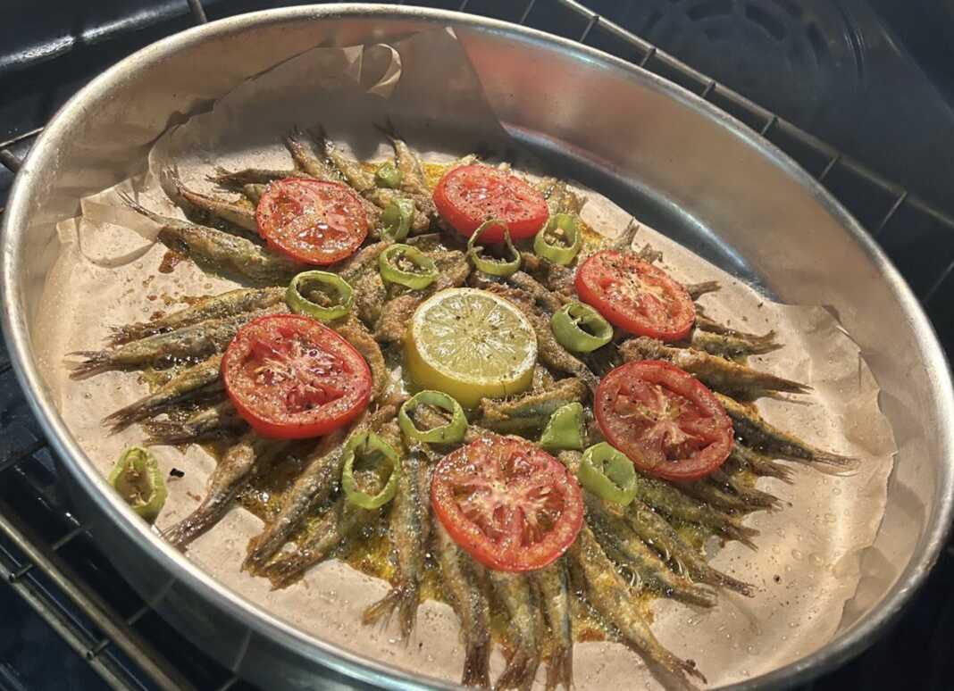 Γαύρος ψητός στο φούρνο, σερβιρισμένος σε πιάτο, με φέτες λεμονιού ντομάτας