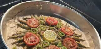 Γαύρος ψητός στο φούρνο, σερβιρισμένος σε πιάτο, με φέτες λεμονιού ντομάτας