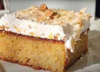 Αφράτη καρυδόπιτα σε ταψί καλυμμένη με πλούσια στρώση σαντιγί και πασπαλισμένη με χοντροκομμένα καρύδια