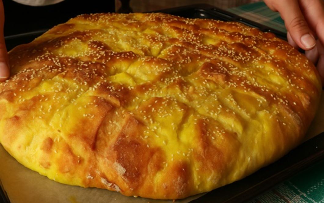 kalampikisio psomi Ένα ολόκληρο αφράτο ψωμί από καλαμπόκι σε ξύλινο πάγκο, με χρυσαφένια κρούστα