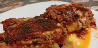 Κοντινό πλάνο σε ένα κομμάτι Κανελόνια με κιμά σε πιάτο, που αναδεικνύει την πλούσια γέμιση και τη χρυσαφένια επιφάνεια