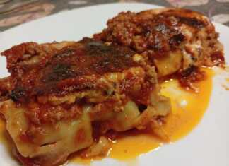 Κοντινό πλάνο σε ένα κομμάτι Κανελόνια με κιμά σε πιάτο, που αναδεικνύει την πλούσια γέμιση και τη χρυσαφένια επιφάνεια