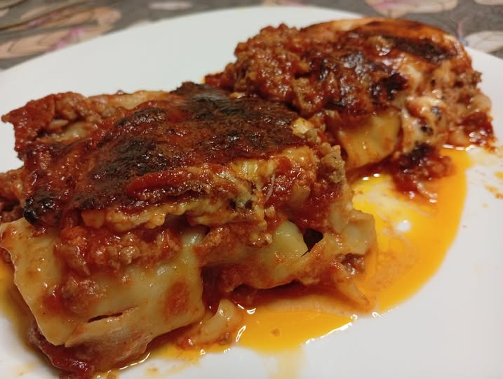 kanelonia kima Κοντινό πλάνο σε ένα κομμάτι Κανελόνια με κιμά σε πιάτο, που αναδεικνύει την πλούσια γέμιση και τη χρυσαφένια επιφάνεια