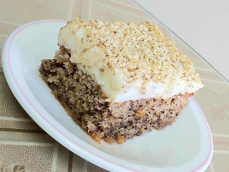 karidopita me krema karidi Μια κομμένη φέτα από καρυδόπιτα με κρέμα, που φαίνονται οι στρώσεις του γλυκού και η κρέμα