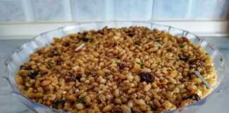 Ένα μπολ με παραδοσιακά Κόλυβα, με την επιφάνεια καλυμμένη από άχνη ζάχαρη και διακοσμημένη με σταυρό από ασημένια ζαχαρωτά και σπόρους ροδιού