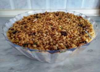 Ένα μπολ με παραδοσιακά Κόλυβα, με την επιφάνεια καλυμμένη από άχνη ζάχαρη και διακοσμημένη με σταυρό από ασημένια ζαχαρωτά και σπόρους ροδιού